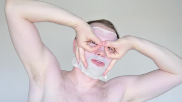 Volwassen blanke man met een cosmetisch masker heeft plezier. — Stockvideo