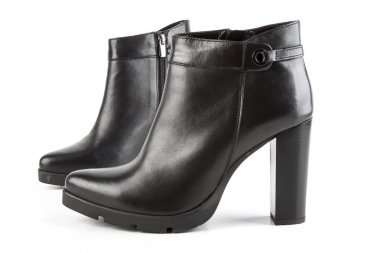 Beyaz arka planda siyah deri kadın botları