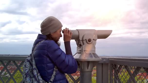 Mulher caucasiana jovem ajusta o foco e olha para o telescópio — Vídeo de Stock
