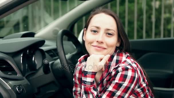 Meisje in een auto glimlachen en kijken naar camera — Stockvideo