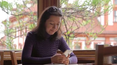 Frau mit app am Smartphone im café