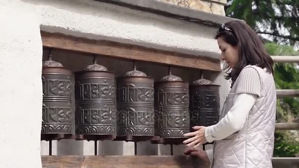 European woman spins prayer wheels — Stock Video