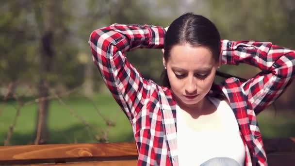 Молода дівчина розчісує довге волосся руками — стокове відео