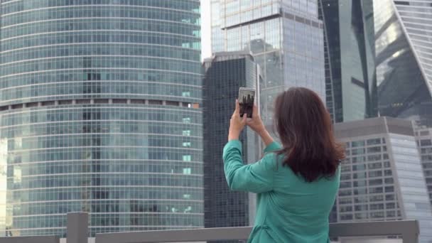 Jeune touriste prend des photos du centre d'affaires — Video