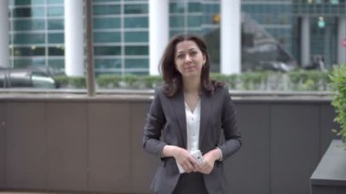 Kadın kameraya yaklaşırken iş elbiseleri