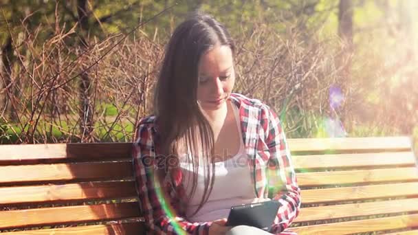 Schöne Studentin surft in der Sonne im Internet — Stockvideo