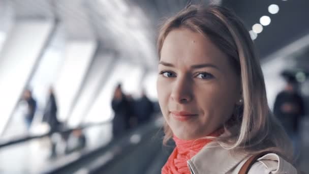 Fiatal szőke nő lovagolva a travelator — Stock videók