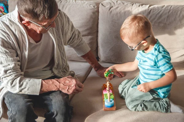 La abuela mayor o el abuelo juegan con su nieto pequeño. — Foto de Stock