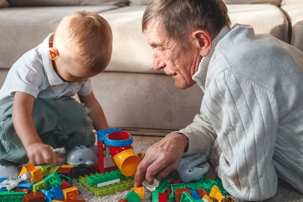 La abuela mayor o el abuelo juegan con su nieto pequeño. — Foto de Stock