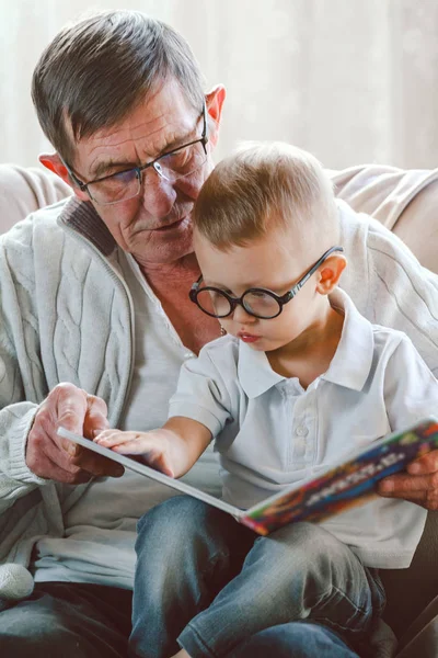 Büyükbabam ve torunum kitap okuyorlar.