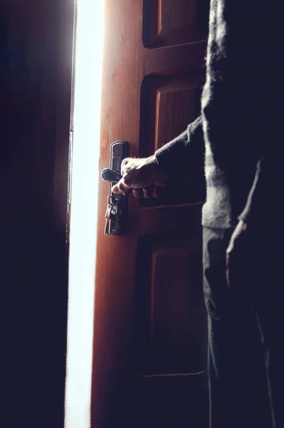 Silhouette of an elderly man opening the door — Stock Photo, Image