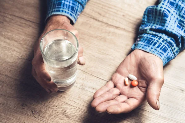 Många flerfärgade piller i en senior händer — Stockfoto