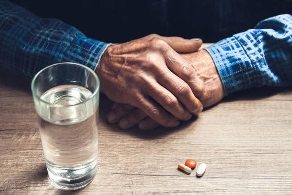 Viele bunte Pillen in der Hand eines Senioren — Stockfoto