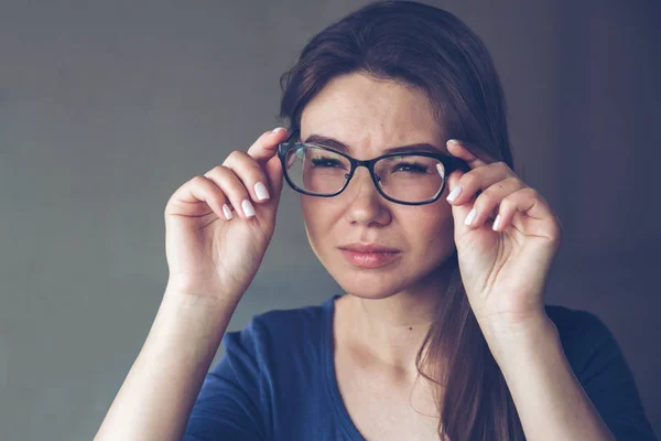 A woman with vision problems hold eyeglasses — Stock Photo, Image