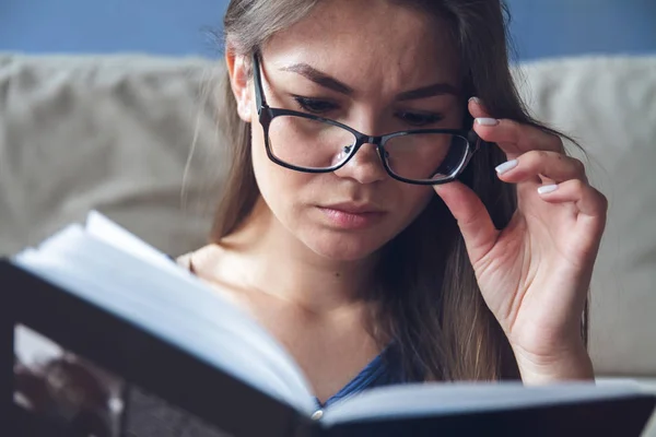 Egy látászavaros nő szemüveges könyvet olvas.. — Stock Fotó