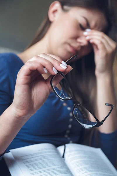 Женщина с проблемами со зрением читает книгу в очках . — стоковое фото
