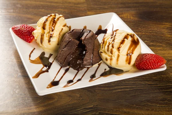 Petit gateau dessert con gelato e fragola su sfondo di legno . — Foto Stock