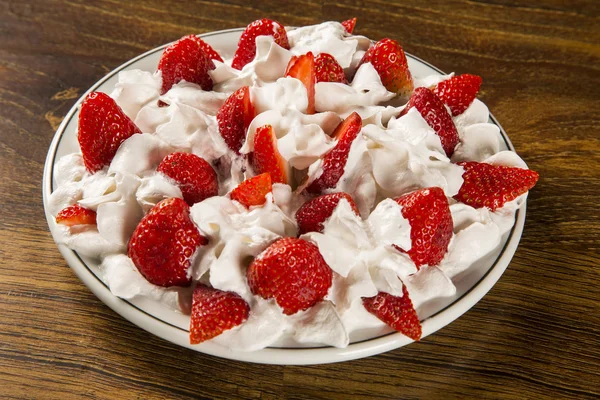 Strawberry with chantilly cream in a dish on a wooden table — Stock Photo, Image