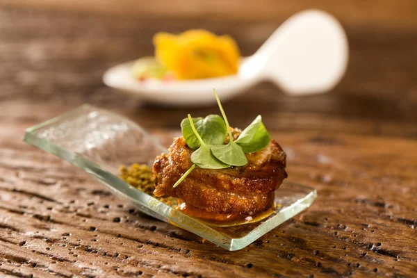 Pork ballotine with pururuca, water flour, pumpkin puree and sprouts in a spoon. — Stock Photo, Image