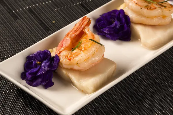 Gegrilde garnalen met rauwe nagel vis op witte plaat aan tafel — Stockfoto