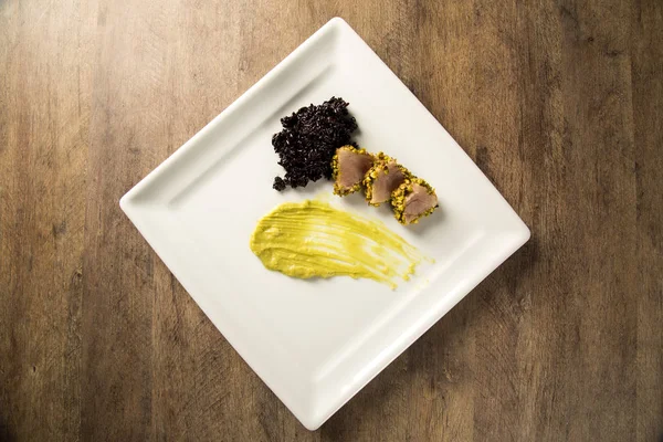 Tonno con crosta di pistacchio, riso nero e purea di avocado — Foto Stock