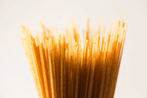 Espagueti amarillo largo integral sobre un fondo rústico. Amarillo. —  Fotos de Stock