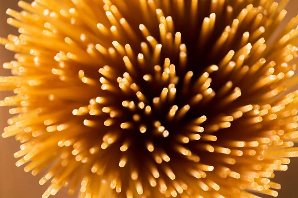 Espagueti amarillo largo integral sobre un fondo rústico. Amarillo. — Foto de Stock