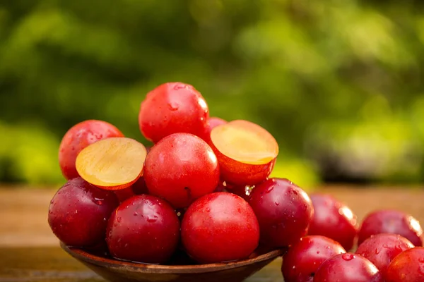 Prunes fraîches et brillantes sur fond en bois — Photo