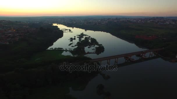 Luchtfoto beeldmateriaal rivier bij zonsondergang in Barra Bonita stad in de staat van de Sao Paulo - Brazilië. Juli, 2016. — Stockvideo