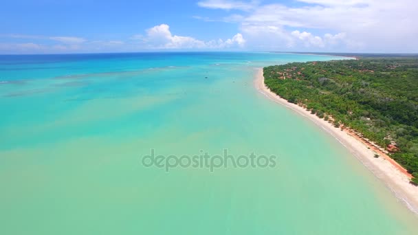 Luchtfoto groene zee op Braziliaanse strand kust op zonnige dag. Cumuruxatiba city, Bahia, Brazilië. Februari, 2017. — Stockvideo