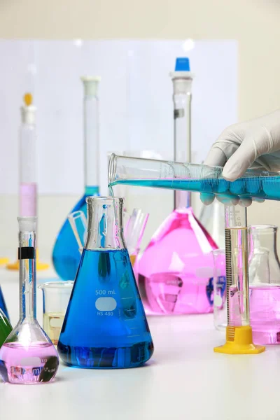 Samenstelling van laboratorium materiaal met gekleurde vloeistoffen in realistische glazen potten chemische testen voor soja en maïs. — Stockfoto
