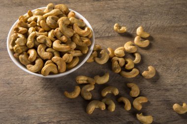 Kaju fıstığı ahşap arka plan üzerinde beyaz kase