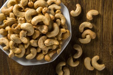 Kaju fıstığı ahşap arka plan üzerinde beyaz kase