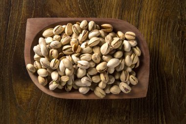 tahta arka plan ile ahşap kase fıstık fındık.