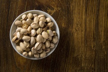 ahşap arka plan beyaz kase fıstık fındık.