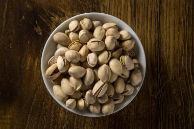 ahşap arka plan beyaz kase fıstık fındık.