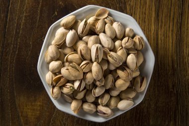 ahşap arka plan beyaz kase fıstık fındık.