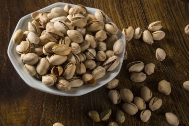 ahşap arka plan beyaz kase fıstık fındık.