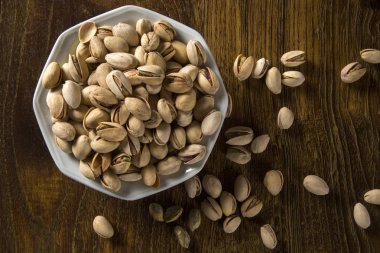 ahşap arka plan beyaz kase fıstık fındık.