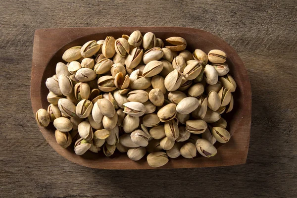 tahta arka plan ile ahşap kase fıstık fındık.