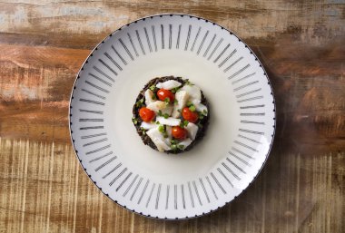 Siyah pirinç risotto ile rendelenmiş cod