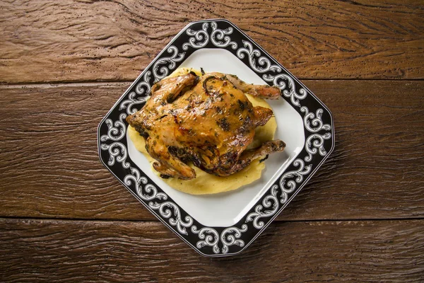 Little Chicken dish with polenta on wood background