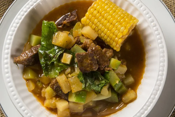 Cocina sudamericana: sopa de puchero con garbanzos de cerca en una olla sobre la mesa . — Foto de Stock
