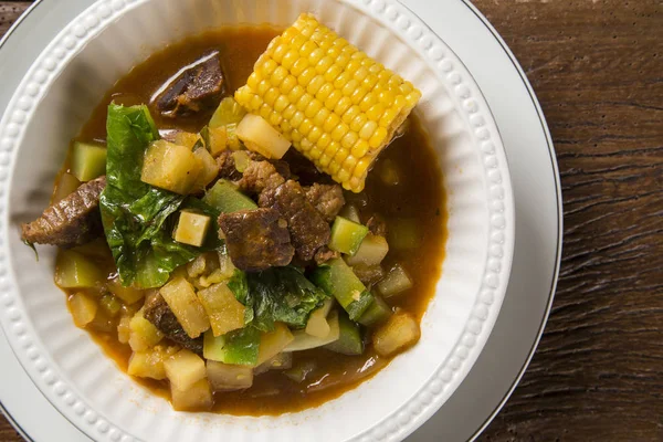 Südamerikanische Küche: Puchero-Suppe mit Kichererbsen in Großaufnahme im Topf auf dem Tisch. — Stockfoto