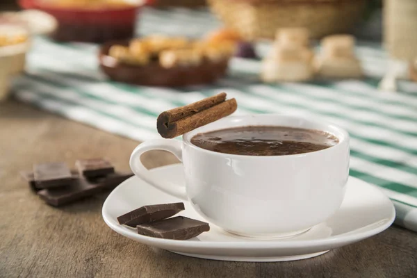 Chocolate caliente en la mesa con algunos brasileños deliciosos. Tema Festa Junina — Foto de Stock