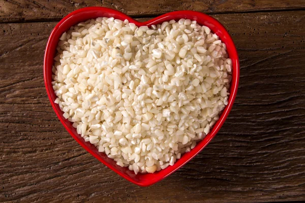 Beyaz ahşap kase mısır taneleri rendelenmiş. canjica / mungunza