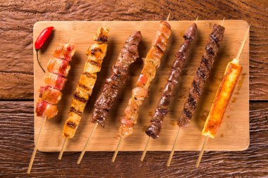 Bir tahta üzerine çeşitli biftek şişleri