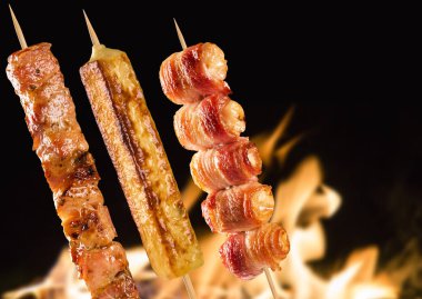 Yangın arka plan üzerinde çeşitli biftek şişleri