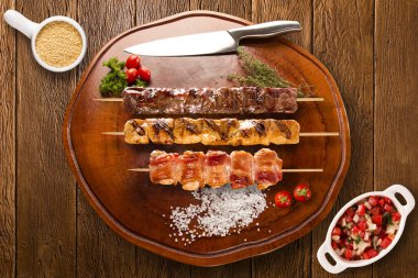 Bir tahta üzerine çeşitli biftek şişleri