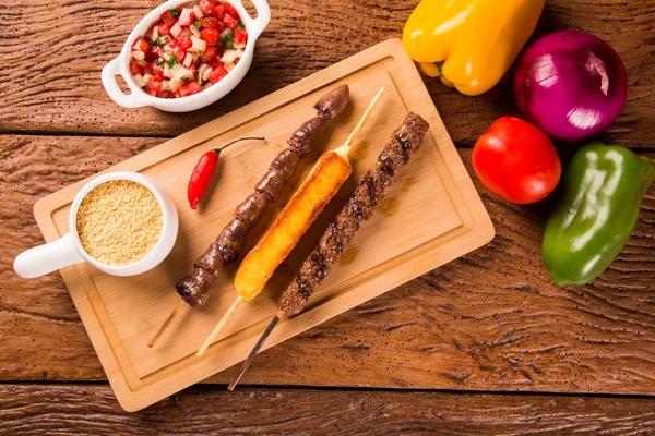Bir tahta üzerine çeşitli biftek şişleri